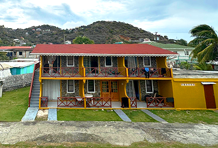 a yellow hotel with red roof