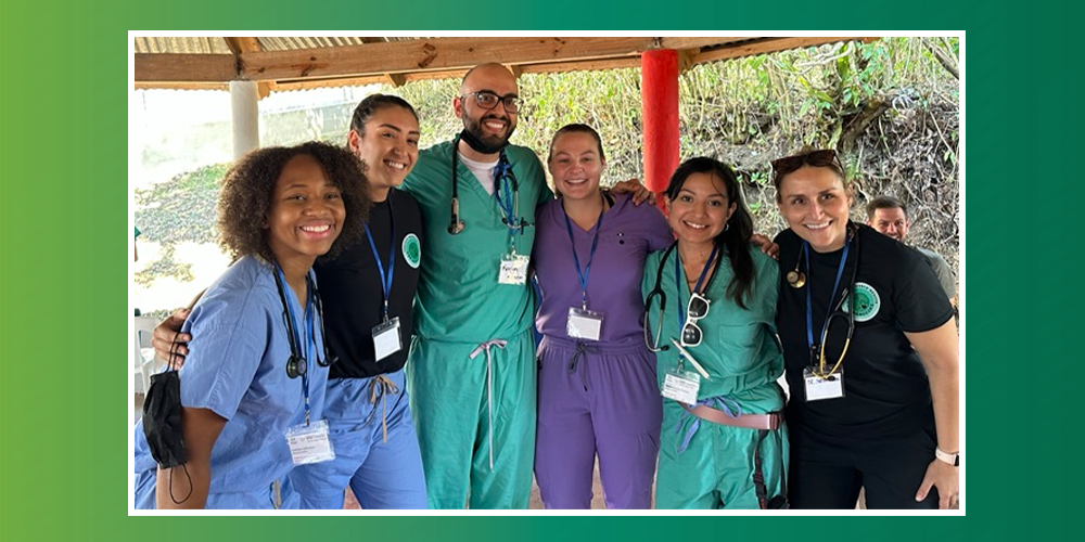 Smiling doctors and USF health students from World Project Health stand together in a rural outdoor treatment area in the Dominican Republic