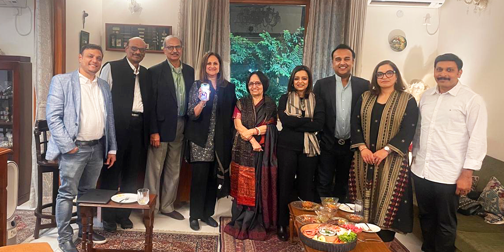 A group of alumni standing in a room, smiling