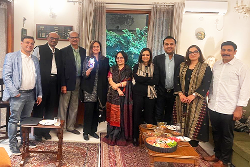 A group of alumni standing in a room, smiling