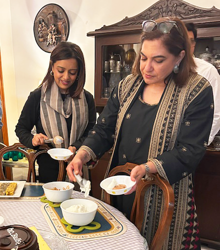 Two people dipping food onto plates