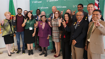 group of fulbright recipients and USF leadership holding up the bulls sign with their hands