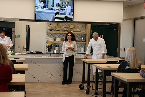 A professor speaking to class in a kitchen setting